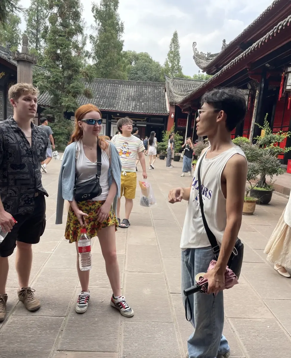 Travellers talking with a local guide in a Yunnan courtyard