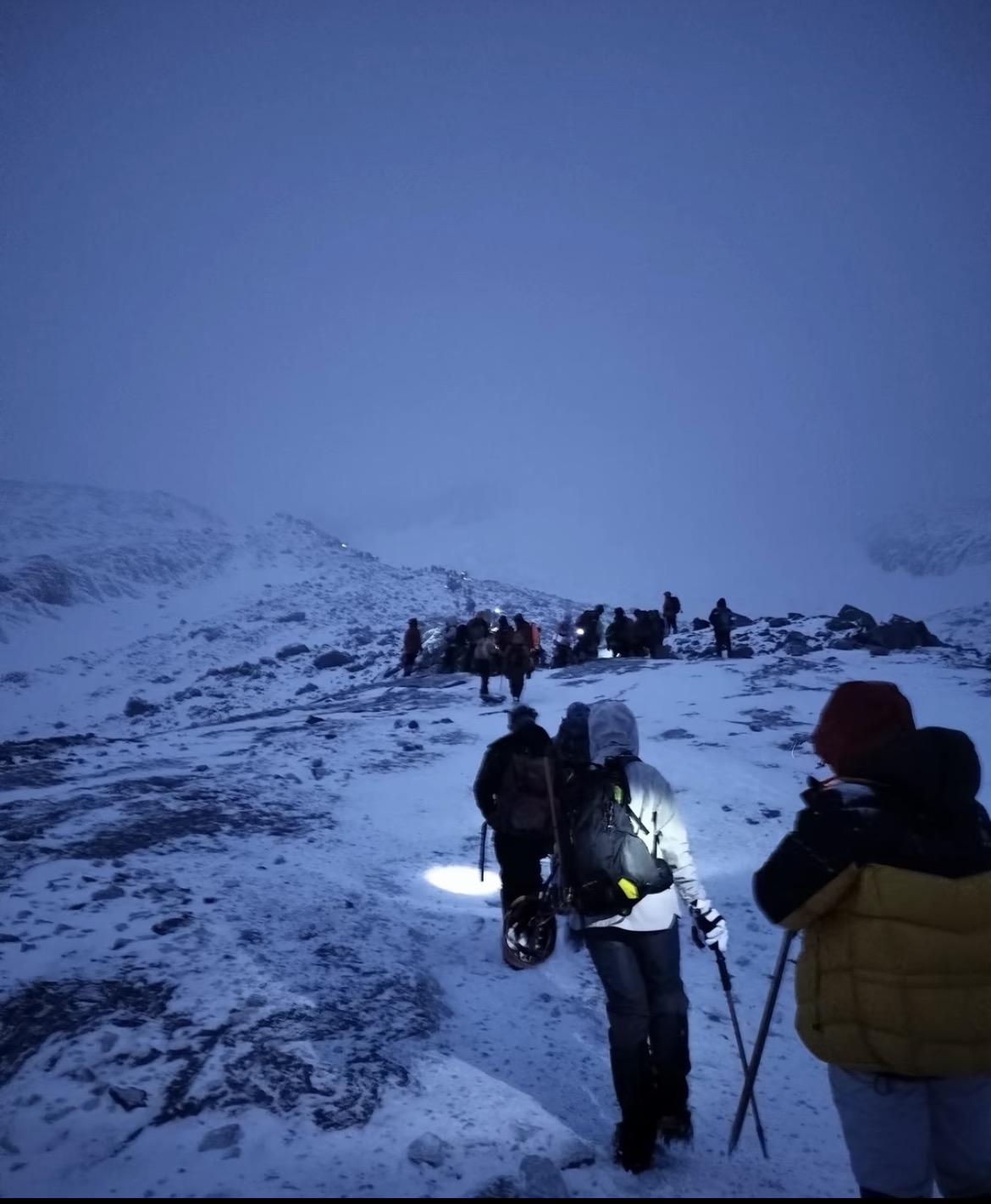 Climbers ascending in a line before dawn