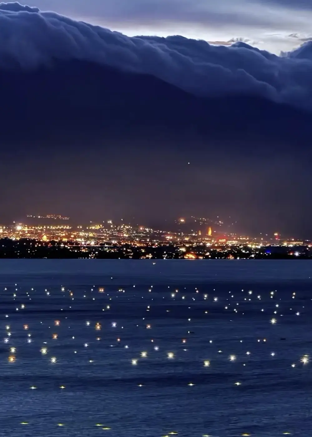 Fishing lights beneath clouds over Cangshan and Erhai Lake